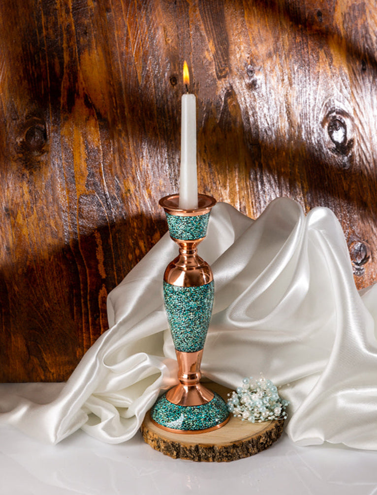 Decorative candle holder with a candle on a white fabric against a wooden background